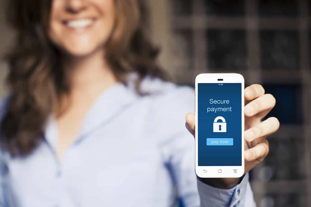 woman holding smart phone showing a secure digital payment