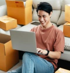 Man with moving boxes and laptop