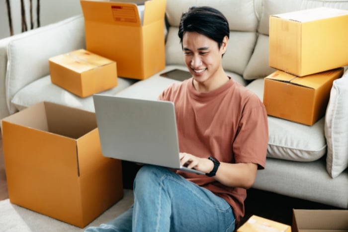Man with moving boxes and laptop