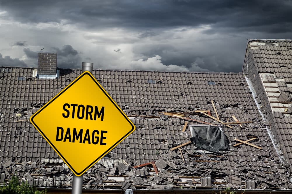 Storm Damage sign near damaged roof